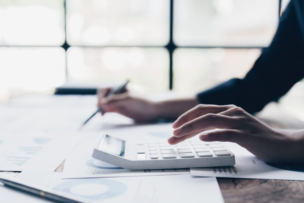 Close up Business woman hand using calculator to calculate the company's financial results and budget. Account Audit Concept